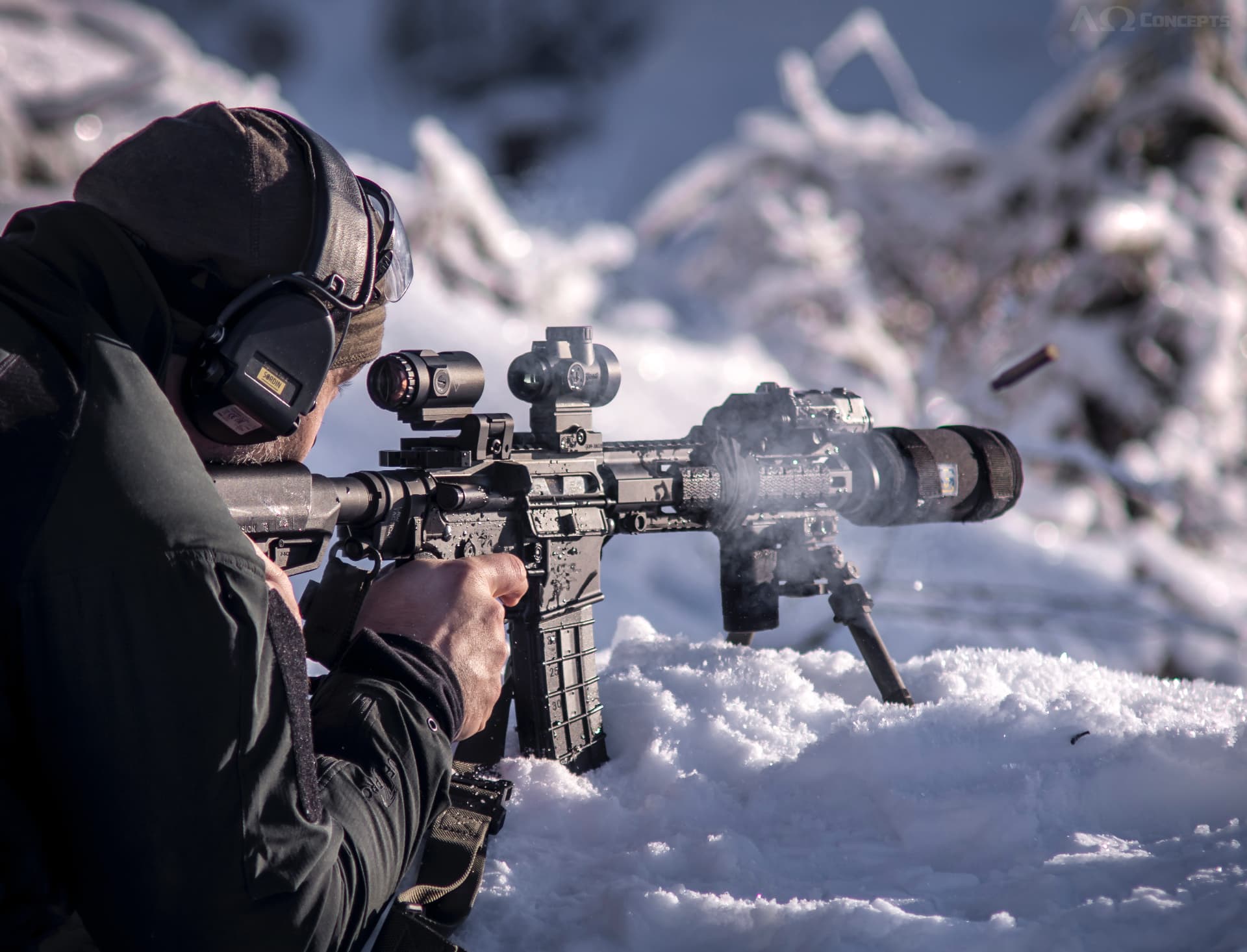 Shooter with suppressed rifle in snowy winter conditions